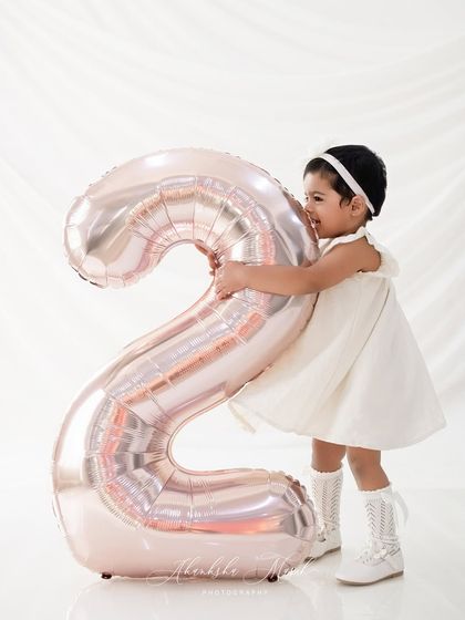 So much love for turning two. This candid shot of the birthday girl hugging her balloon is absolutely precious and shows the sweet, affectionate nature of toddlers.