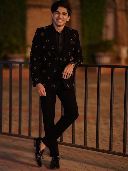 A few shots from a photoshoot for a men's ethnic wear brand, showcasing a sharp, all-black reception look.