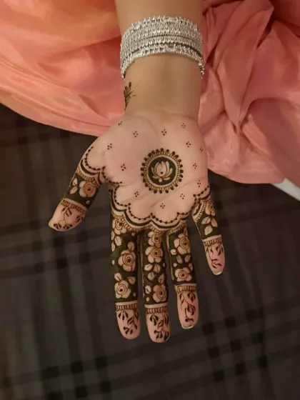 A beautiful design with a central lotus mandala and floral patterns on the fingers.