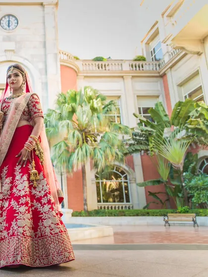 A duplicate of ID 92, a magnificent portrait of the bride in her stunning red lehenga, set against the grand architecture of a palace-like venue.
