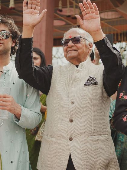 A grandfather enjoying the festivities with a big smile and hands in the air. It is a beautiful thing to see every generation celebrating together.