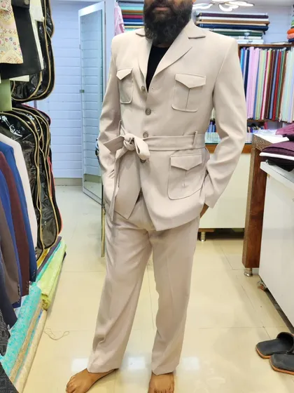 A client trying on his unique belted safari suit. This is a great example of how we can create custom, non-traditional outfits for wedding events that are sure to steal the show.