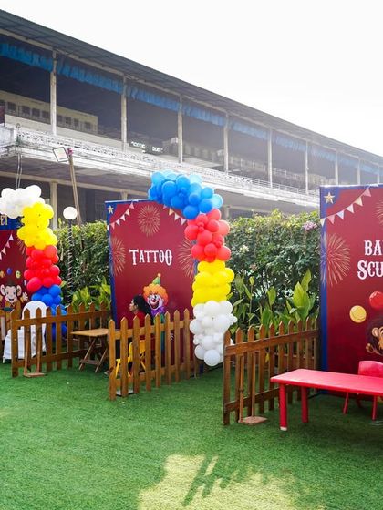 A variety of activity stalls set up on the lawn, including a tattoo station and a balloon sculptor, for creative fun.