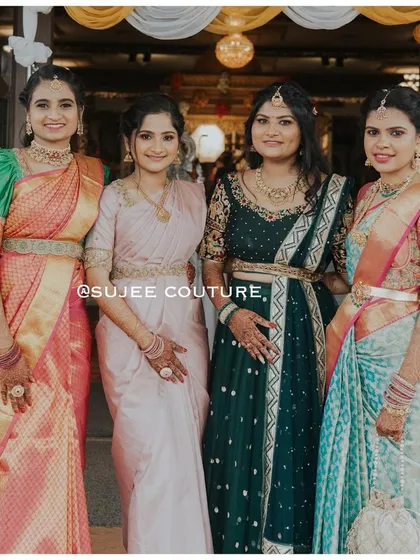 A group of lovely clients, each wearing a unique custom outfit for a wedding. From the green puff-sleeve blouse to the dark green Anarkali-style lehenga, it shows the variety of occasion wear I create.