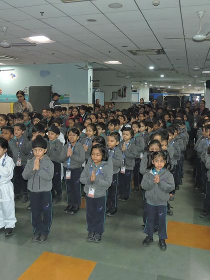 The entire student body stands together in prayer during the assembly, reflecting on the importance of empathy and community.
