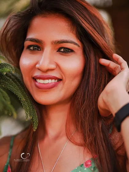 A happy and candid close-up that captures a moment of pure joy. Her bright smile is infectious, and the natural setting adds to the relaxed vibe.