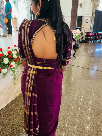A back view of a client in a deep purple saree, wearing a custom blouse with a high neck and a large keyhole back.