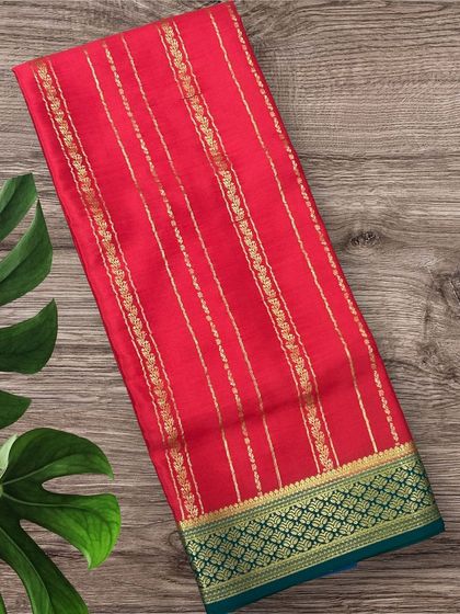 A vibrant red pure crepe Mysore silk saree with gold stripes and a beautiful green contrast border.