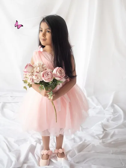 Holding a bouquet of flowers, this birthday girl looks like she's stepped out of a storybook. A little butterfly adds a whimsical touch.