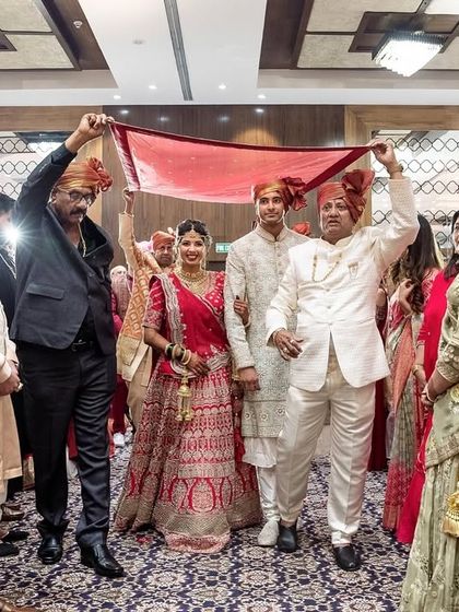 Walking on cloud nine. The bride makes her grand entrance under a beautiful phoolon ki chadar held by her brothers and father.