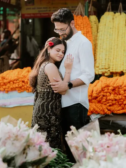 A quiet embrace amidst the vibrant marigolds. This shot beautifully contrasts the couple's serene moment with the lively colors of the flower market.