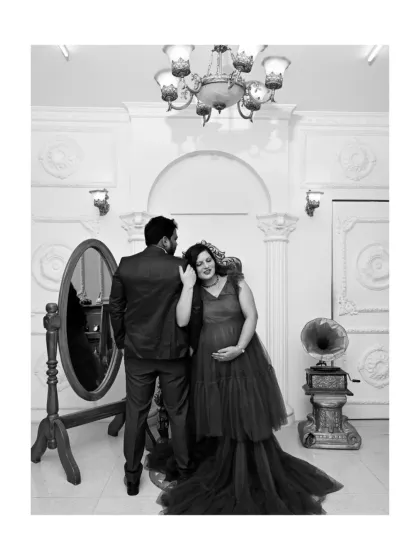 A timeless black and white photo that adds a touch of old-world glamour. This candid-style shot captures a quiet moment between the couple against the backdrop of our elegant, vintage-inspired studio set.