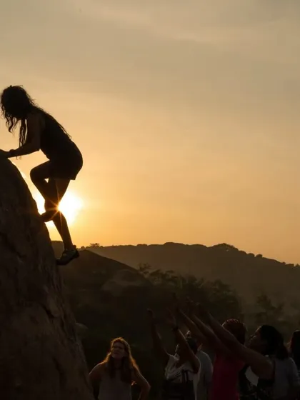 No experience is needed to join our outdoor events! This silhouette captures the magic of a sunset climb in Hampi, with the whole crew below offering their support.