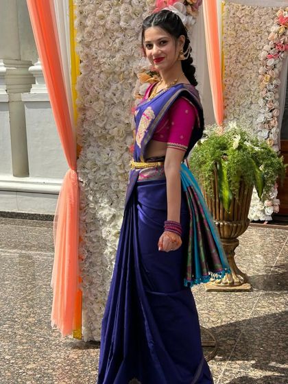A client in a royal blue saree with a multi-colored border, paired with a contrasting bright pink blouse.
