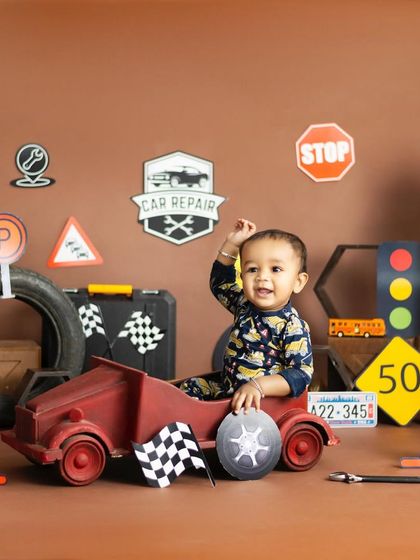 This little guy is having a blast in his car repair shop. Themed shoots are a great way to capture your child's interests.
