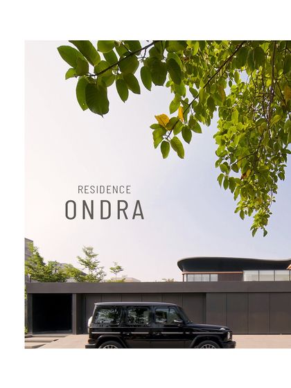 The entrance to Residence Ondra in Amritsar is intentionally discreet, concealed behind a monolithic wall. This design choice ensures complete privacy from the street, with only a hint of the sweeping architectural forms that lie beyond.