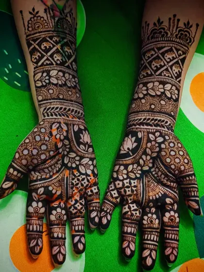 A close-up of the palms, showing the detailed floral and elephant patterns.