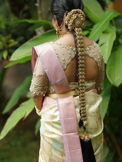 A close-up of the back of the bride's blouse, showing the intricate embroidery and the beautiful cut-out design.