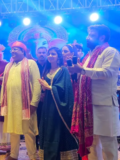 A candid moment of prayer and music on stage at a Ganpati celebration. Every performance is an offering from the heart.
