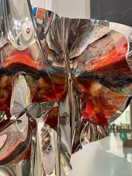 A surprise detail on the interior fold of the sculpture reveals a burst of abstract, earthy colors.