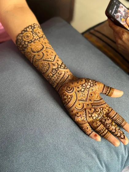 A real-life shot of the design being applied, showing the fresh, dark paste from my organic henna cones.