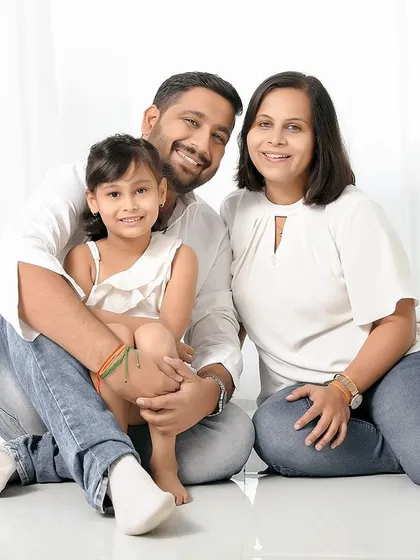 A simple and sweet family portrait against a clean white background. The focus is entirely on the family's happy expressions and connection.