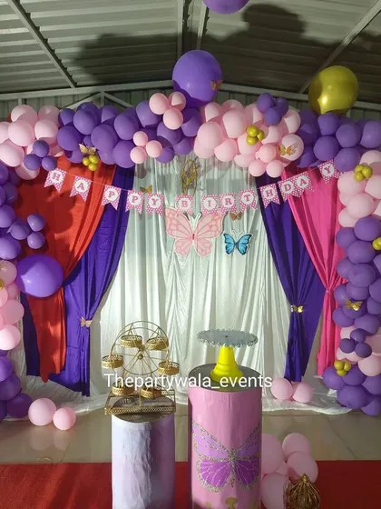A butterfly theme using drapes and a "Happy Birthday" banner. The purple and pink color combination is a classic choice for a fun and vibrant party.