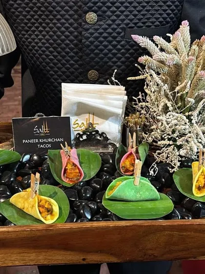 A creative fusion of Indian flavours and Mexican form. These colourful mini tacos are filled with spiced Paneer Khurchan and presented on a bed of black stones with dried flowers for a dramatic effect.