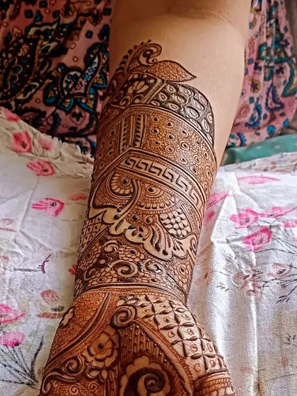 A detailed design on the arm featuring a peacock and geometric patterns.