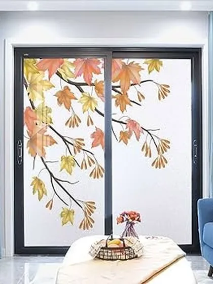 A beautiful example of a frosted film with a nature-inspired design. The autumn leaves pattern adds a touch of elegance and privacy to this living room's sliding glass doors, blending seamlessly with the home decor.