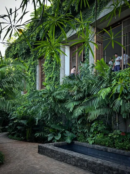 The monsoon brings the landscape at Villa Toshi to life. The lush greenery, including a vertical garden climbing the walls, helps to cool the building and integrate it into the tropical environment.
