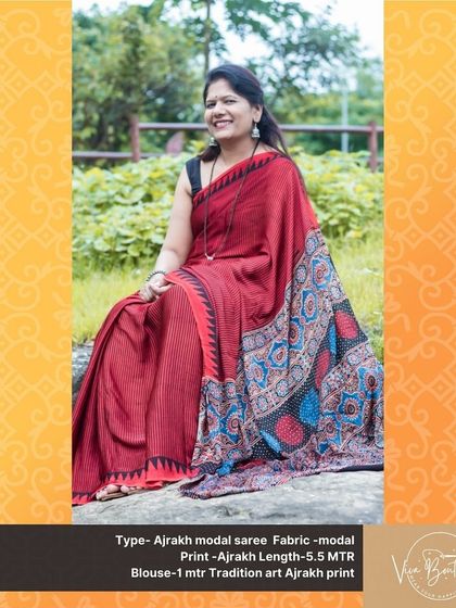 A seated portrait of a customer in our red Ajrakh modal saree. The rich color and beautiful drape make it an effortlessly elegant choice.