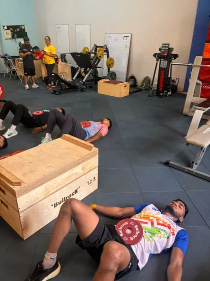 A close-up of our breathwork session. The small weight plate on the abdomen provides tactile feedback, helping the athlete focus on deep, diaphragmatic breathing for better nervous system regulation.