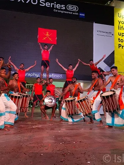A wide shot capturing the full ensemble of performers, including Chenda Melam drummers and army acrobats, at the 'Vijay Parv' event. I make sure to get shots that show the scale and collaborative energy of a performance.