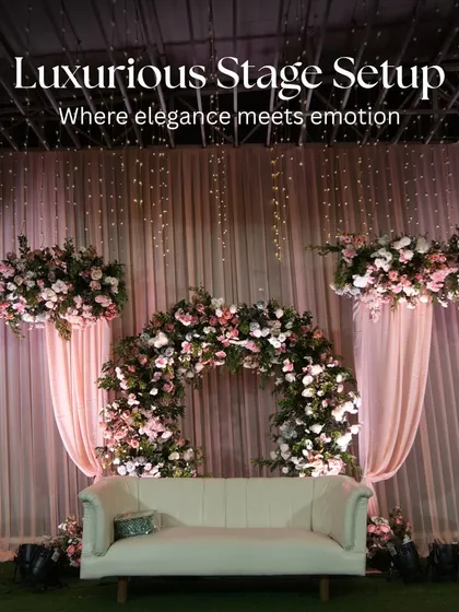 A luxurious stage setup for a reception, where elegance meets emotion. This design features a beautiful floral arch, soft pink draping, and dramatic lighting, creating the perfect focal point for the happy couple.