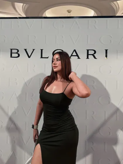 Standing in front of a Bvlgari backdrop in the sophisticated black gown.