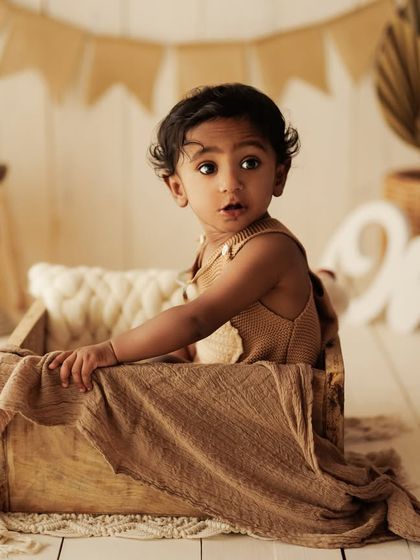 A slightly different pose, showing the baby looking over their shoulder with a curious expression.