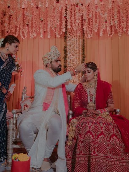 A full view of the couple at the mandap, surrounded by the beautiful floral decor.