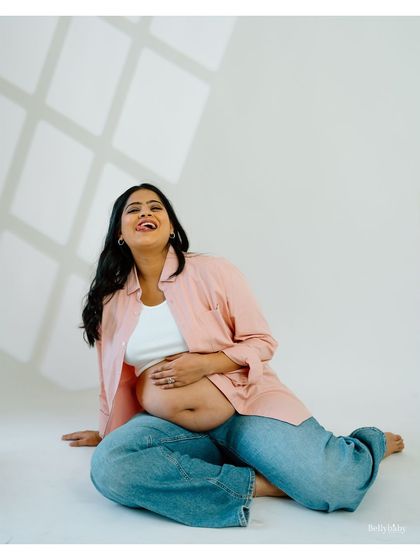 Pure, infectious joy! This candid shot of a mom-to-be laughing in a casual, comfy outfit shows that maternity photos can be fun and full of personality.