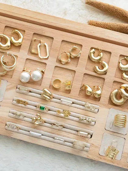 A wide shot of our accessory tray, filled with a variety of our anti-tarnish and waterproof earrings and rings, ready to be styled.