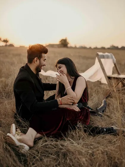 Sitting together in the field as the sun sets, sharing a quiet, happy moment. This image captures the peaceful and comfortable intimacy that comes from a long and happy relationship.