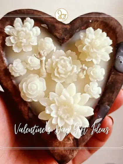 A Valentine's Day gift idea: our wooden heart candle. The intricate, hand-poured white wax flowers create a stunning contrast against the dark wood, making it a symbol of pure love.