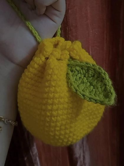 This is my crochet lemon pouch, a cute and zesty little bag perfect for carrying coins or earbuds. The design includes a little green leaf for a realistic touch.