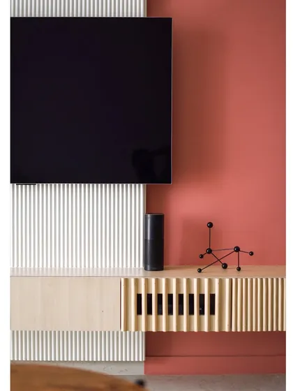 A close-up of the TV unit, which features a mix of fluted and smooth panels. The design is a beautiful study in texture and color.