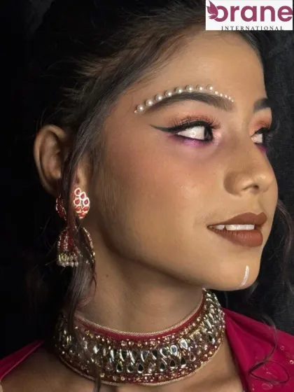 This look features pearl embellishments above the brow, adding a unique and artistic touch to the makeup.