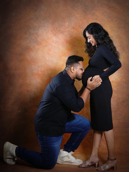A classic and heartfelt pose where the father-to-be kneels to kiss the baby bump. It's a beautiful way to show his connection and love for their coming child.