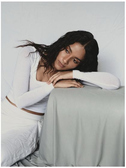A pensive and gentle portrait. The model's head resting on her arms creates a feeling of introspection and calm. This pose is great for conveying a softer, more emotional side.