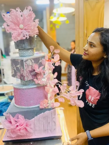 A shot of me adding the final touches to an elaborate, artistic wedding cake.