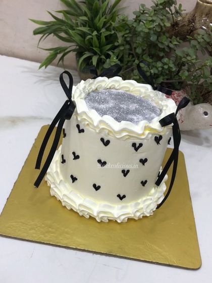 A chic glitter cake with black hearts and delicate black ribbon bows. This design is simple, modern, and perfect for a stylish birthday or bachelorette party.