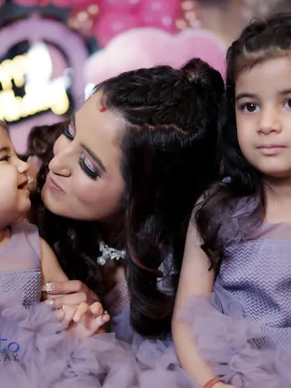 A candid moment of affection between a mother and her two daughters. These natural shots often become the most treasured memories from a family event.